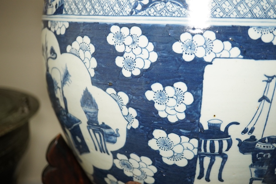 A large Chinese blue and white ‘Hundred Antiques’ jardinere and hongmu stand, late 19th/early 20th century